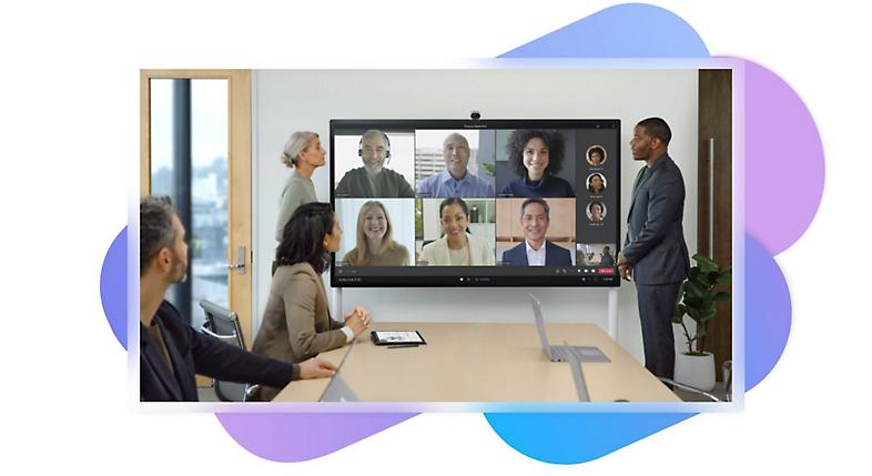 Um grupo de pessoas numa sala de reuniões a participar numa chamada do Teams através de uma televisão instalada numa parede atrás das mesmas.