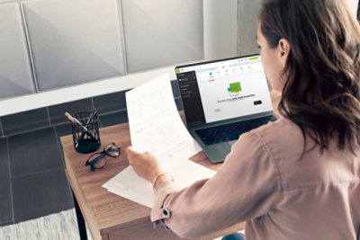 A person working at their desk with a laptop displaying the H&R Block website