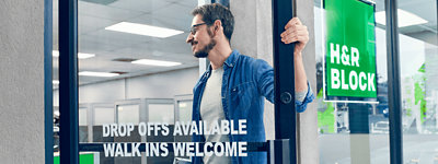 A person walking into an H&R Block