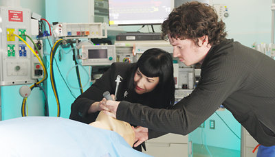 A man and woman looking at a woman's face.