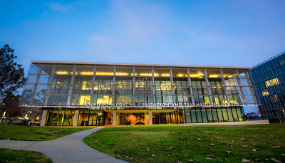 A building with many windows under a blue sky with clouds