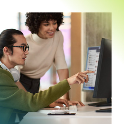Two persons discussing over desktop in an office