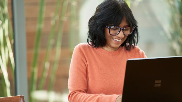 Woman seated using a Windows PC. 