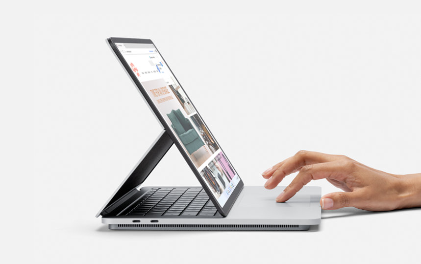Seitenansicht auf ein Surface Laptop Studio. Eine Hand bedient das Touchpad.