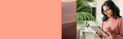 A girl is watching a tablet near a plant.