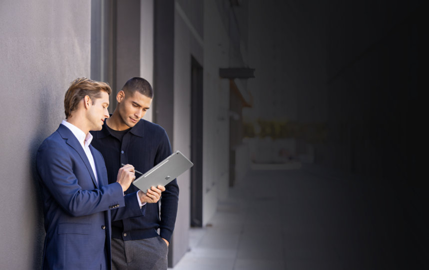 Two men standing outside while using a Platinum 12 inch Surface Pro with a Surface Pen.