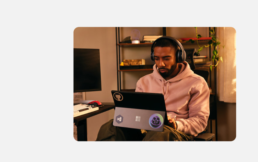 自宅のデスクでキーボード付き Surface Pro を操作する開発者。