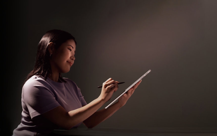 Woman holding Surface Pro and pen.