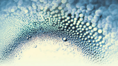 Water droplets and circles on a white and dark blue gradient background.