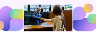 A bank worker and a customer shaking hands.