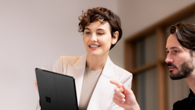 A man and woman looking at a Platinum Surface Pro in tablet mode.