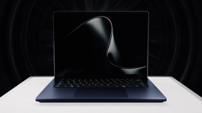 Image of the Windows logo placed on the back of a Surface on a black background.