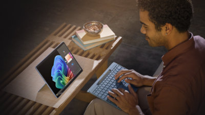 Person using Surface Pro (12th Edition) Copilot+ PC in Sapphire, holding the detached Pro Flex Keyboard.