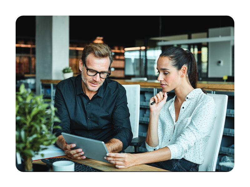 Two colleagues collaborating at a laptop in a modern office