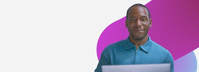 Ein Mann, der einen Laptop vor einem lila Hintergrund hält.