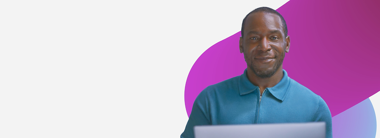 A man holding a laptop in front of a purple background.