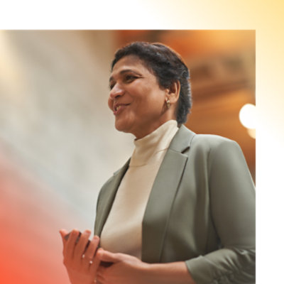 A woman in jacket holding her hand and smiling