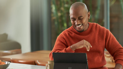 Eine Person, die lächelt und auf einen Laptop schaut