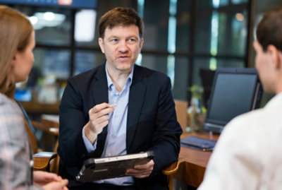 A person in a suit holding a tablet