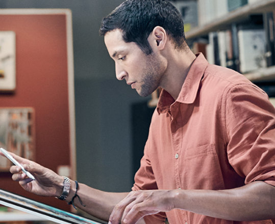 Photograph of two people working in a studio using pens on large tablet screens.