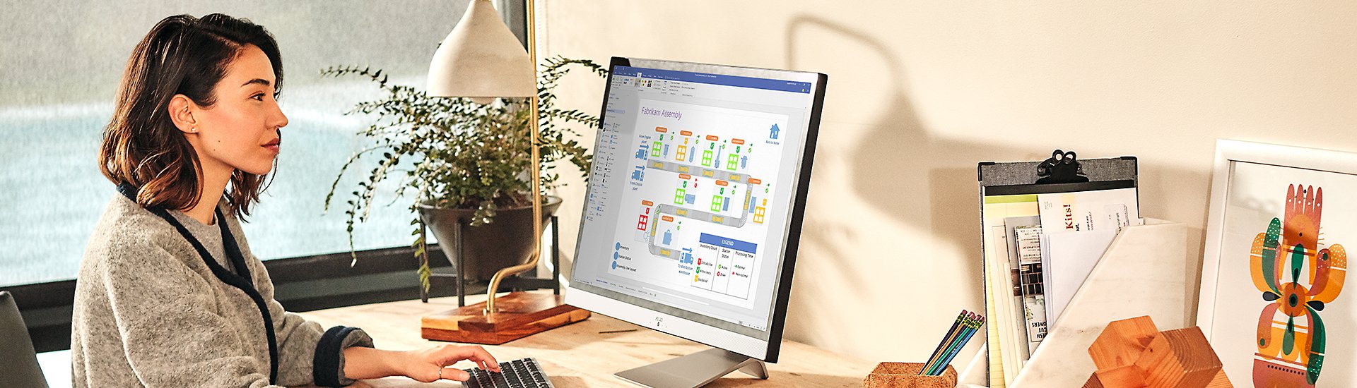 A person looking at a file in Visio on a large desktop monitor