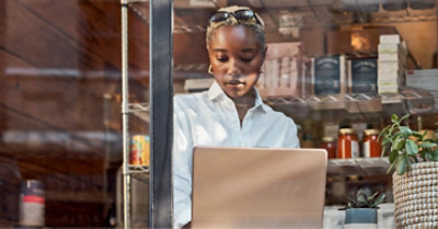 A person sitting in front of a window using a laptop.