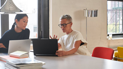 Two professionals reviewing work in an office.