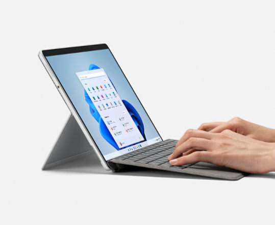 Una persona sostiene la Pluma para Surface y trabaja con Surface Pro 8.