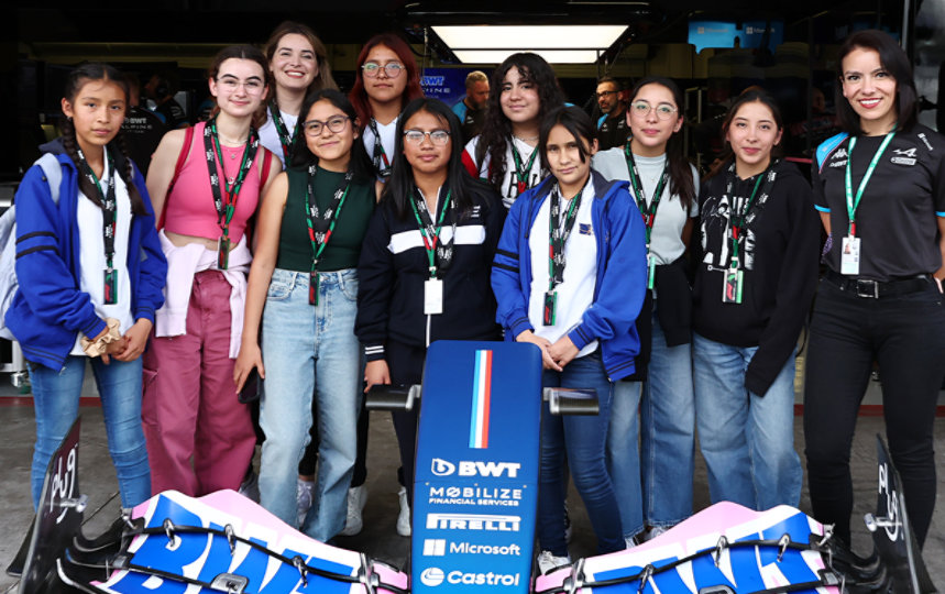 A group of young women stand next to the B W T Alpine F 1 car.
