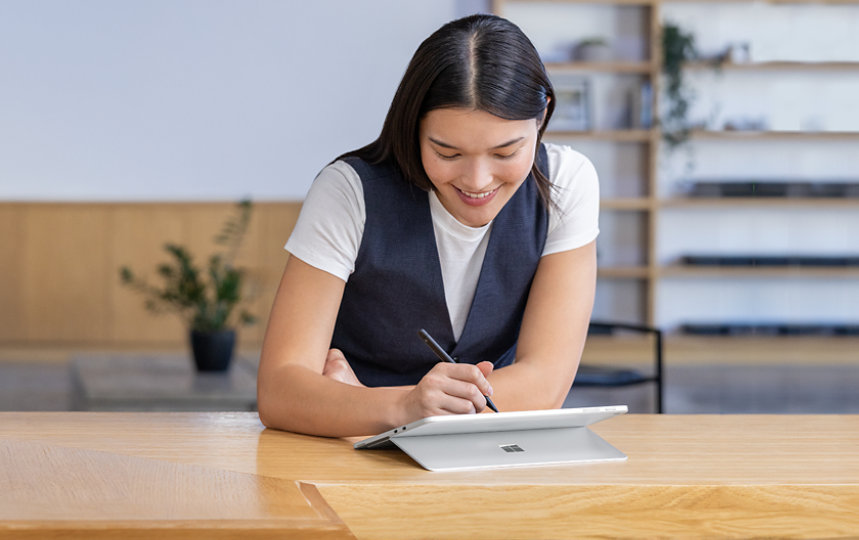 キックスタンドモードの Platinum Surface Pro を Surface ペンで使用している女性。
