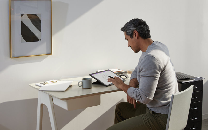 A person works at home using a Surface device.