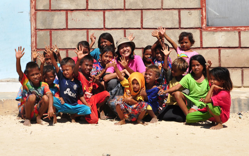 Shana Fatina, CEO and founder of Komodo Water, and a group of village children.