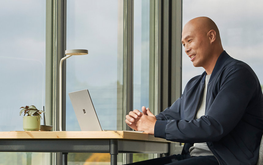 自宅のデスクでSurface Laptop Go 2を使ってTeams通話をする人。