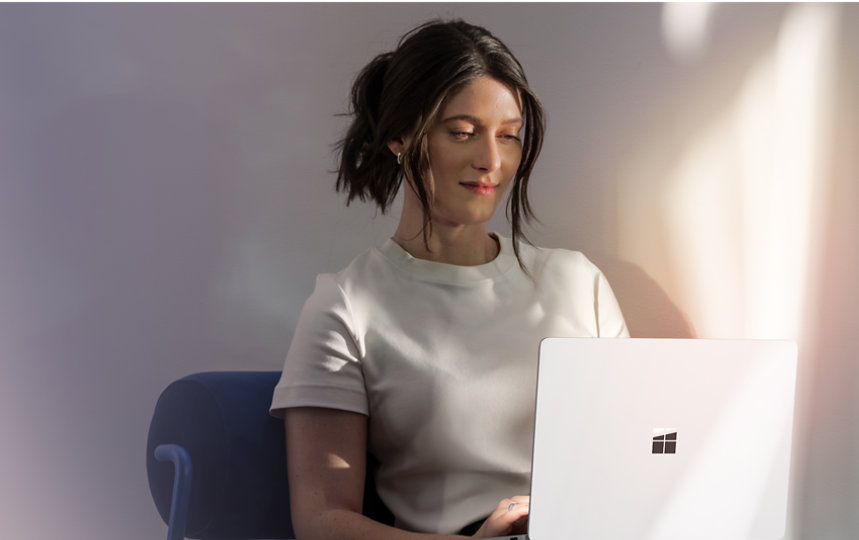 Surface Laptop 7th Edition を膝の上で使用している女性。