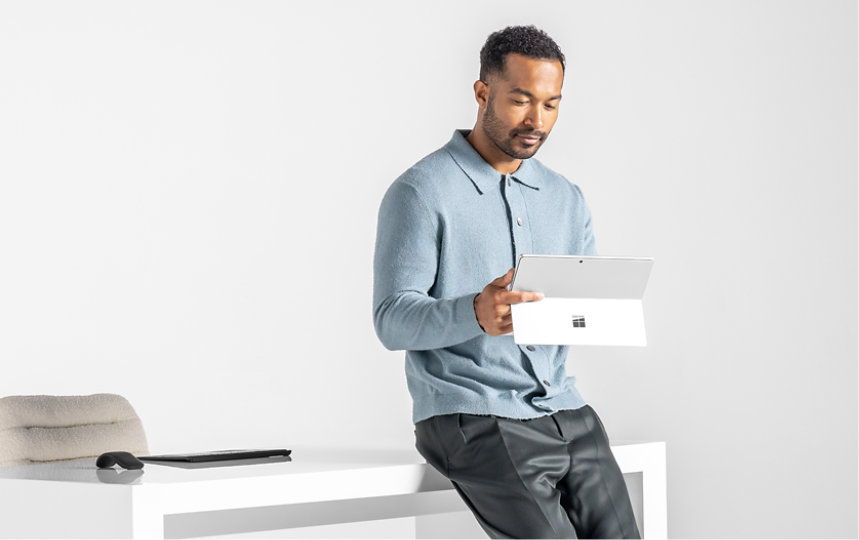 テーブルに座り、Surface Proのタッチ機能を使う人。