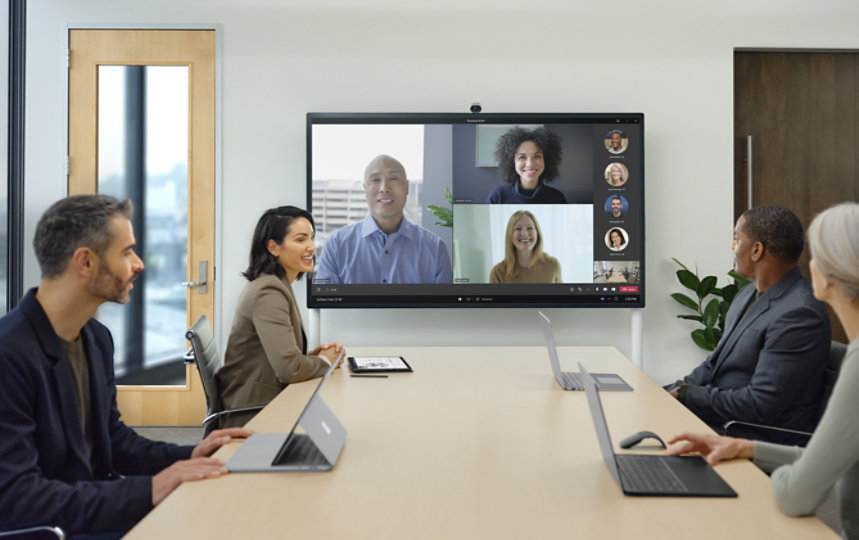 Eine Teambesprechung via Video mit einer Surface Hub Smart Camera über dem Bildschirm.