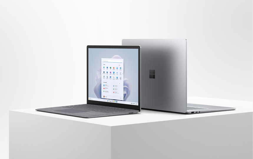 開かれた状態で台の上に背中合わせに置かれている、13.5 インチと 15 インチの Surface Laptop 5。  