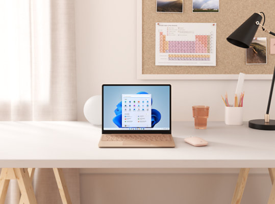 Sandstone Surface Laptop Go on a desk.