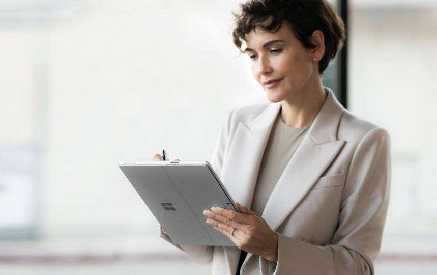 A businesswoman writes on a Surface Pro with a Surface Slim Pen.