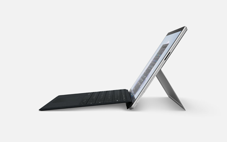 A platinum Surface Pro 9 tablet in profile with black keyboard.