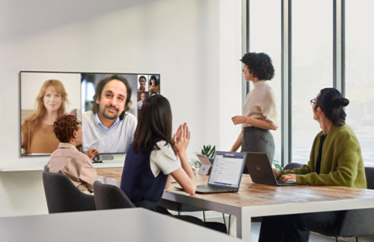 People at a conference table attending a virtual meeting 
