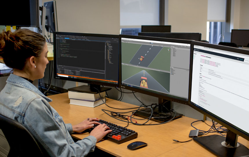 A developer uses Visual Studio on three computer monitors at work.
