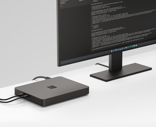 A Windows Dev Kit 2023 connected to two desktop computer displays that are running developer apps.