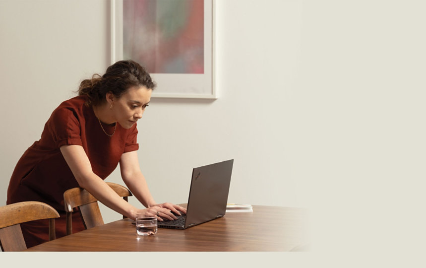 A person using Microsoft 365 with a laptop on a conference room table.