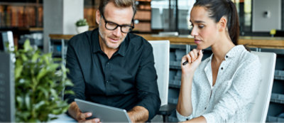 A person and another person looking at a tablet
