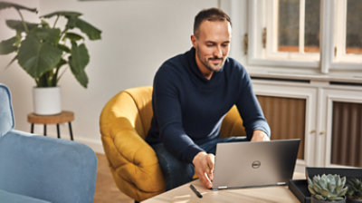 Persona sentada en una silla usando un equipo portátil.