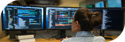 Una persona trabajando en su puesto con varias pantallas.