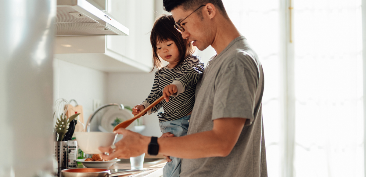 Father and daughter cooking together in kitchen at home