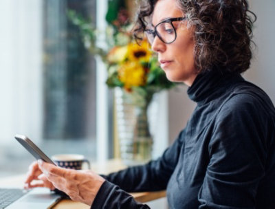 Business person looking at phone for two-factor authentication.