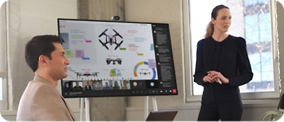 A woman presents data on a Microsoft Surface Hub 2S during a Teams meeting
